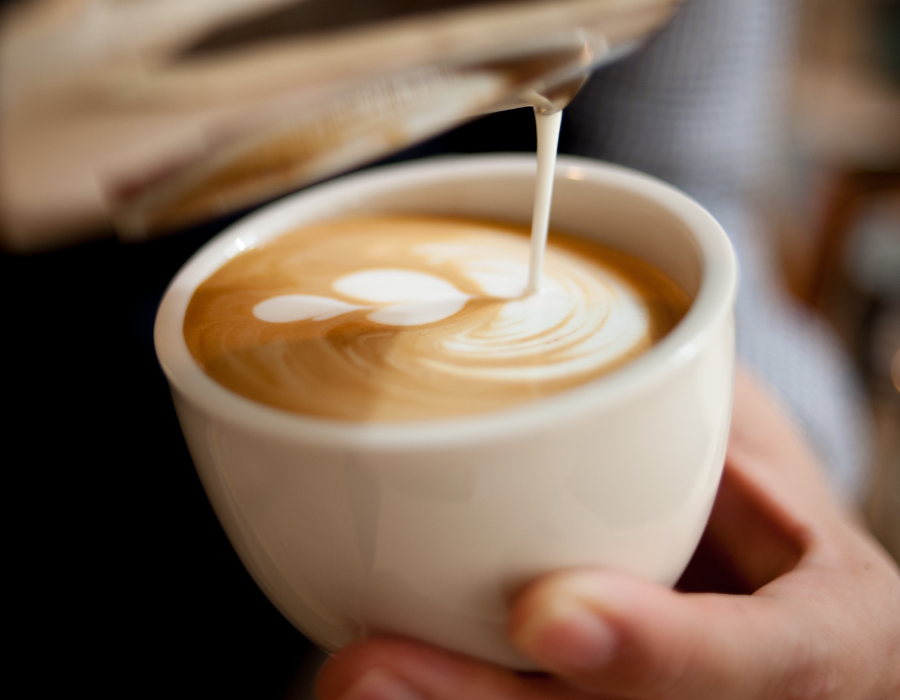 a close up of a barista doing coffee art